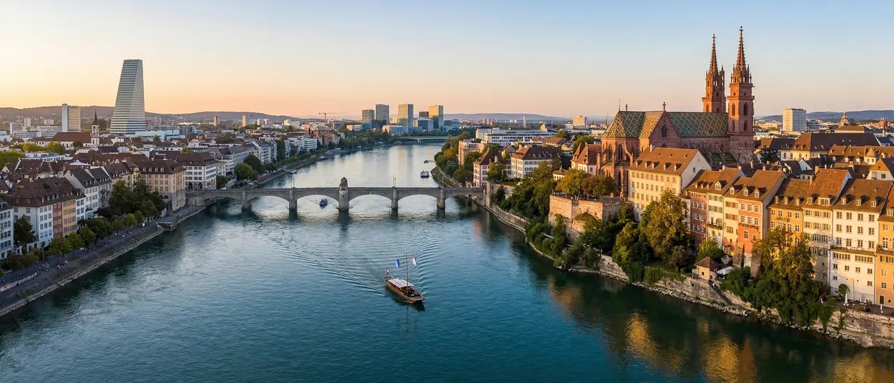 Blick auf Basel mit dem Rhein, der Brücke und dem Münster bei Sonnenaufgang