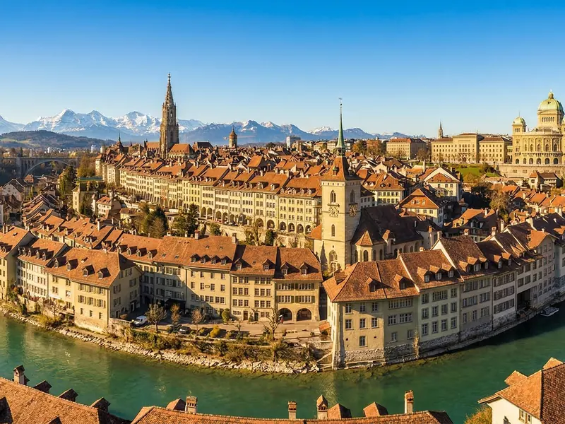 Luftaufnahme der Berner Altstadt, umflossen von der Aare, mit den Alpen im Hintergrund
